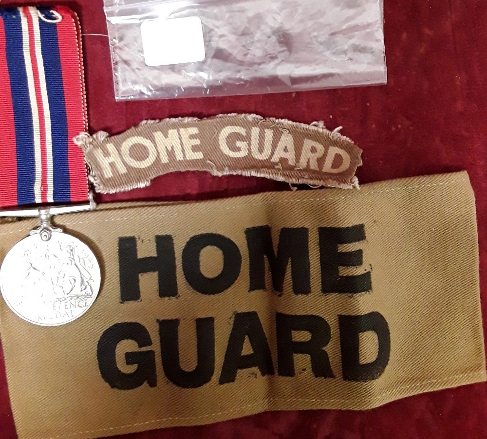 An original WW2 printed Home Guard armband and shoulder flash together with a Defence Medal