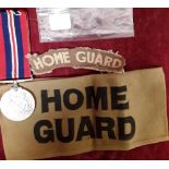 An original WW2 printed Home Guard armband and shoulder flash together with a Defence Medal