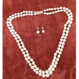 A double stranded necklace of graduated pearls with matching earrings.
