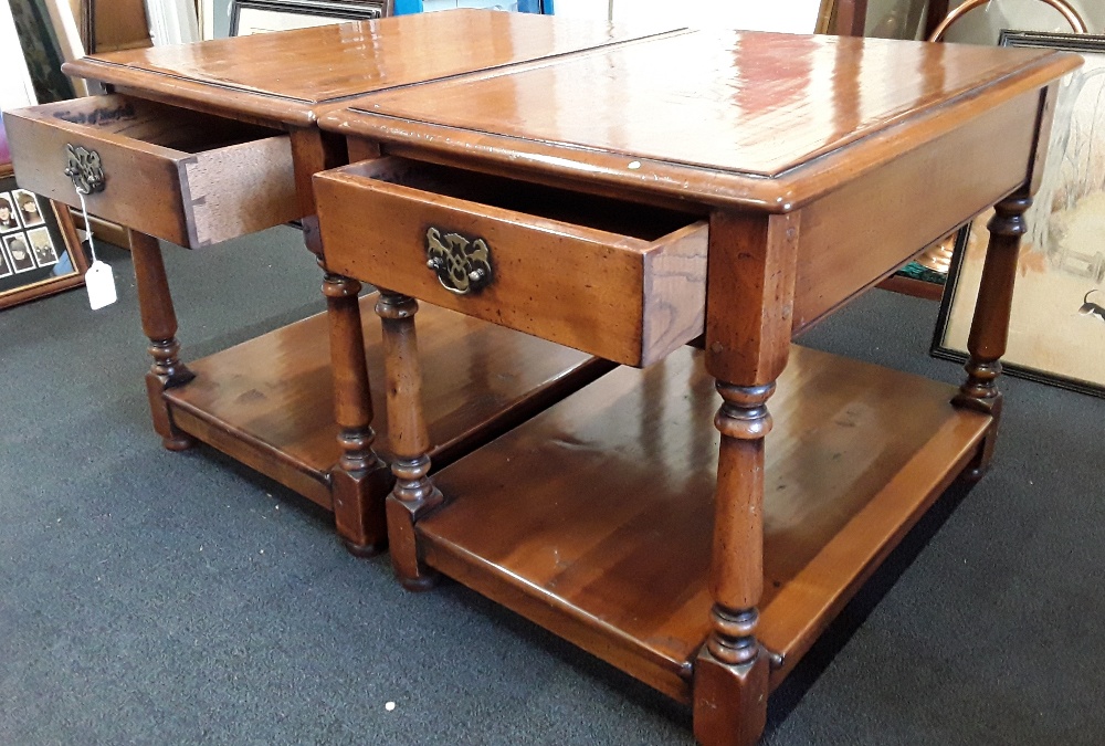 Two matching mahogany side tables each with a small drawer and shelf.