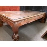 A large Oriental hardwood coffee table with glass top.