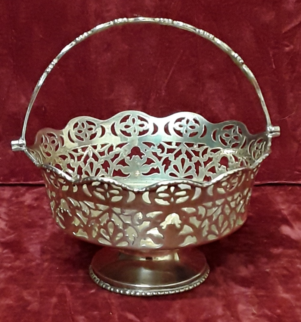 A silver bonbon basket with pierced decoration and handle.