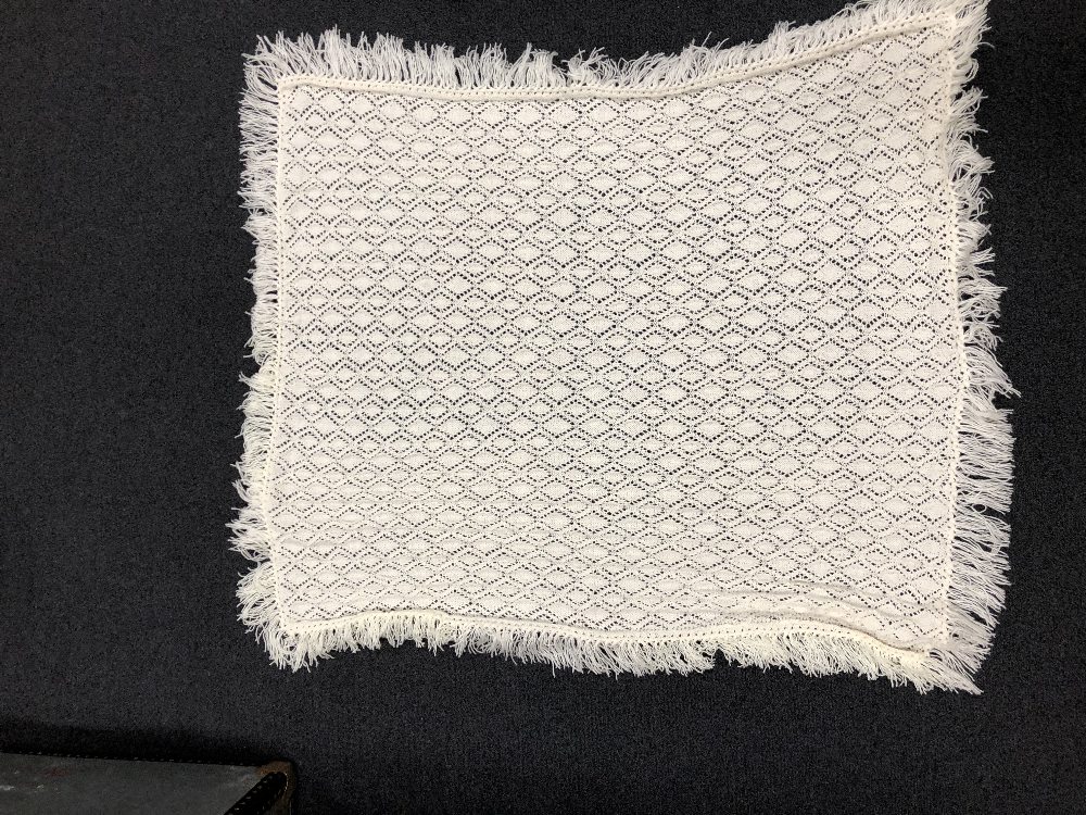 A beautiful hand knitted cot or christening blanket.