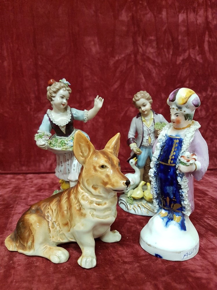 A small collection of three figurines plus a figure of a Corgi dog.