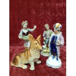 A small collection of three figurines plus a figure of a Corgi dog.