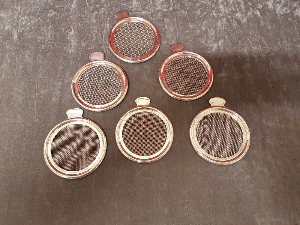 A set of six silver plated drink covers/strainers by Asprey of London.