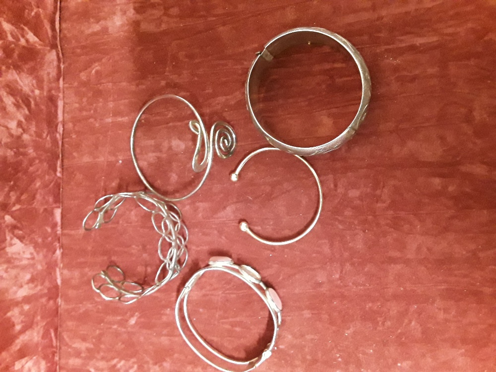 A collection of four silver and white metal bangles plus one precious yellow metal bangle. - Image 3 of 5