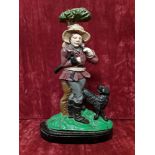 A cast iron door stop in shape of a gamekeeper with black dog