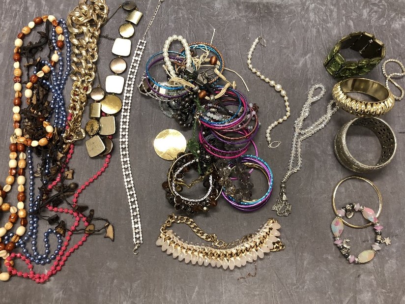 A box of costume jewellery – mostly necklaces and bracelets.