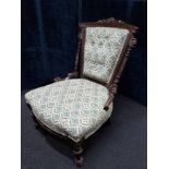 A Victorian mahogany nursing chair of small proportions.