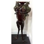 A tall decorative display piece with three legs of unusual form.