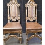 Two high back carved oak chairs with leather inserts into backs and leather seats.