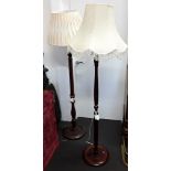 Two turned mahogany standard lamp stands with shades
