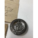 A WW1 Silver War Badge for Services Rendered with document and posting envelope.