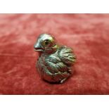 A miniature silver figure of a chick set with glass eyes.