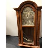 An Acctim clock in wooden case. Pendulum enclosed and Westminster chime.