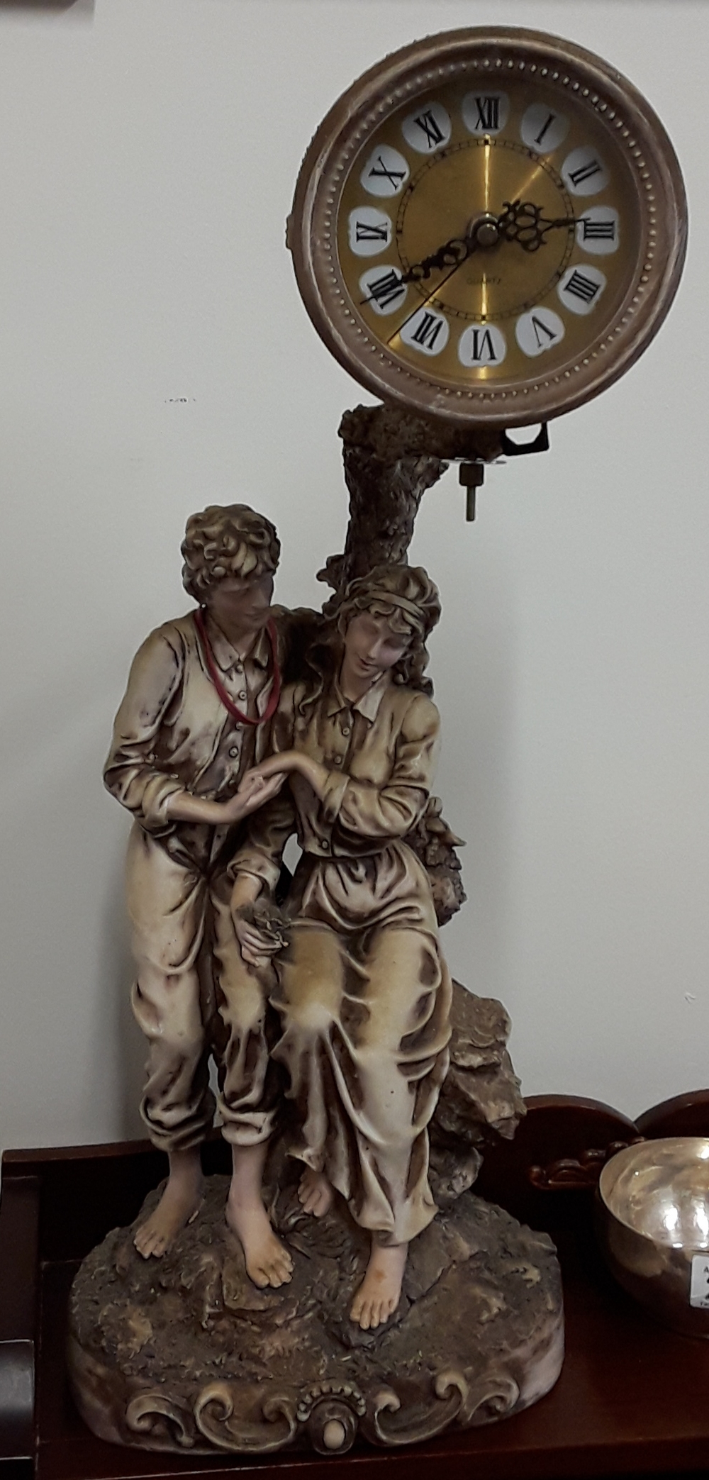 A Contemporary Academy Collection figurine sculpture of couple sitting beneath a clock.