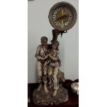 A Contemporary Academy Collection figurine sculpture of couple sitting beneath a clock.