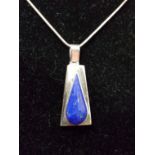 A silver pendant set with lapis lazuli suspended on a silver chain.