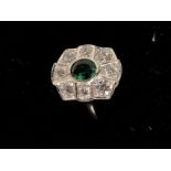 A silver and CZ dress ring with central green tourmaline.