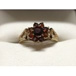 A 9ct yellow gold ring with diamond cut shoulders to mount and set with rubies.