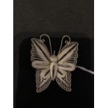 A silver filigree butterfly brooch.