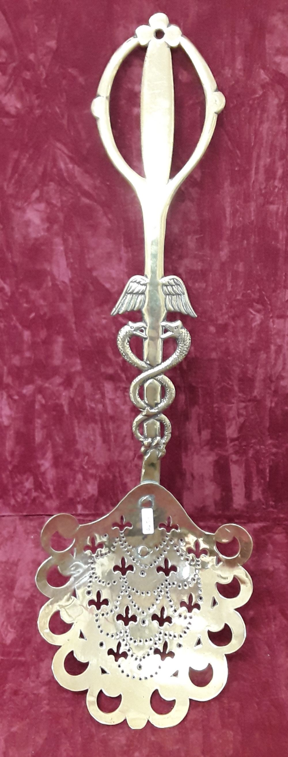 A decorative brass skimmer.