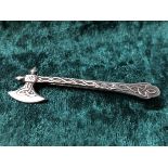 A silver brooch in the form of an axe with Celtic design.