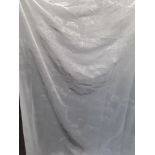 A long white fine polyester curtain with silvered patterning.