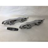 A pair of chrome plated Jaguar car ornaments and a Jaguar side panel badge.