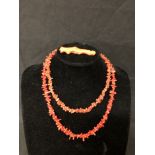 Two red coral necklaces and a piece of red coral stem.