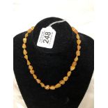 A butterscotch, lemon and honey amber necklace of knotted beads.