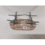 A flight of four WW2 cast aluminium fighter aircraft mounted on a marble base.