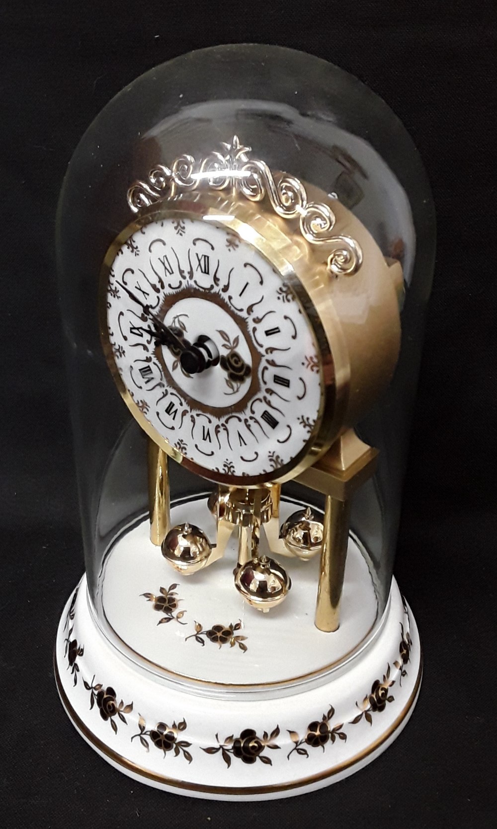 A domed revolving pendulum mantel clock with a porcelain base. - Image 3 of 3
