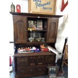 A small mahogany Welsh dresser with heavily carved grape vine decoration to the doors