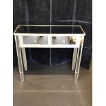 A contemporary glass topped side table.