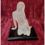 An Art Nouveau style opaque resin figurine of a naked lady on an ebonised base.