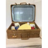 A vintage wicker picnic hamper with plastic utensils dating form the 1960s/70s.