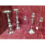 An aluminium candelabrum and a pair of white metal candle pillars.