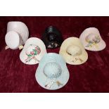 Six ceramic wall pockets in the form of hats with flowers decoration