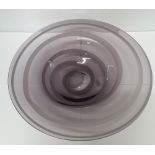 A large glass Murano style bowl with purple rings.