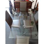 A contemporary four seater glass dining table together with four leather highbacked chairs.