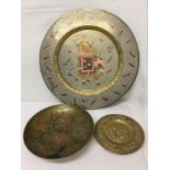 Two brass wall hanging plates and a brass dish, two with enamelling.