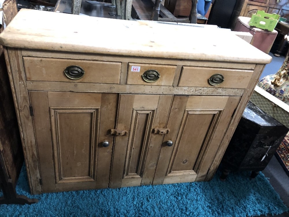 A pine dresser base with three drawers over two cupboards.