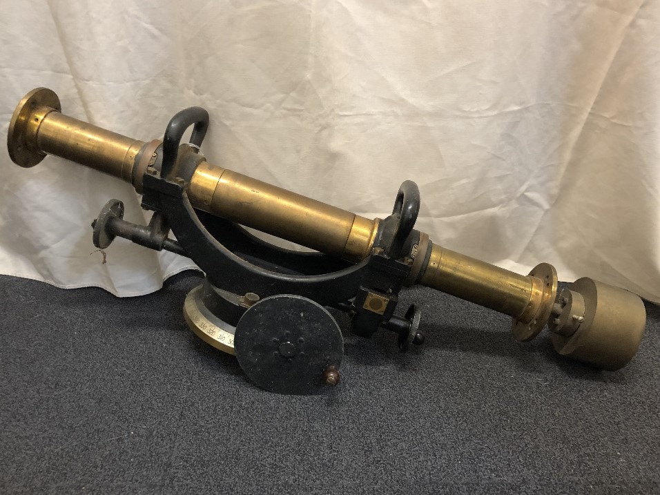 A brass surveyor's tool with handled wheels to alter the direction in different planes.