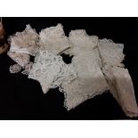 A small quantity of Victorian lace - trims, collars, elbow scarves in a basket.