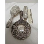 A silver vanity set comprising a comb, hairbrush, hand mirror and clothes brush.