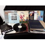 A collection of vinyl records (including 33s and 45s) and two music books