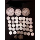 An assortment of silver coinage including two crowns and threepenny bits.