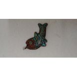 A pendant in the form of a fish, mounted on silver, inlaid with turquoise, red coral and gold.